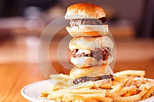 Stack of mini cheeseburgers with fries