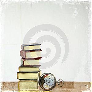 Stack of miniature books and old pocket watch.