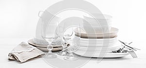 Stack of mixed white dishes and crystal glasses