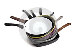 stack of modern stylish multicolored non-stick frying pans on white background