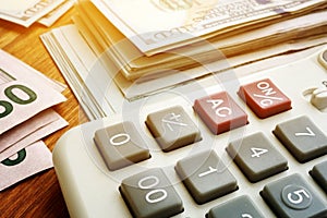 Stack of money and calculator. Budgeting and savings. Dollar banknotes on desk