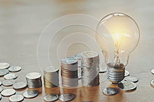 stack money coins growing light bulb concept