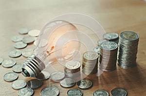 stack money coins with growing light bulb