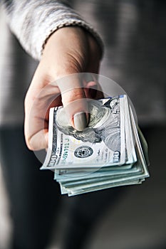 A stack of money, dollars in beautiful female hands. With a beautiful manicure. Business offer. Modern fashion.