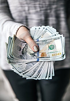 A stack of money, dollars in beautiful female hands. With a beautiful manicure. Business offer. Modern fashion.