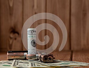 Stack of Money, drugsand a gun on a wooden table, concept about danger and threat of the drug