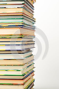 A stack of multi-colored books on a white background with space for writing text