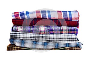 Stack of multicolored checkered winter clothes isolated on white background