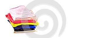 A stack of multicolored knitwear, t-shirts, stacked vertically, isolated on a white background. Banner.