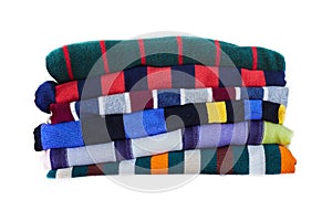 Stack of multicolored striped winter clothes isolated on white background