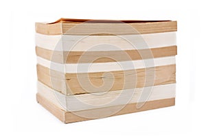 Stack of multiple old and yellowed stacked paperback books on white background