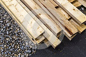 Stack of natural wooden boards on building site. Industrial timber for carpentry, building or repairing, lumber material for