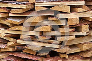 Stack of natural wooden planks with rough edges and bark for construction