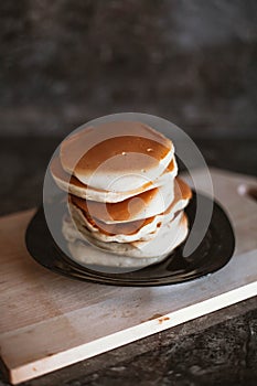 A stack of neat pancakes on a wooden stand