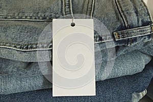 A stack of new jeans with paper price tag mockup. Sale clothing concept