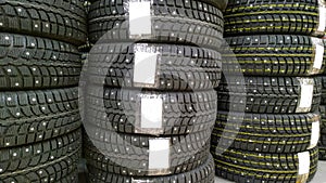 Stack of new studded tires for sale in a supermarket. Professional car service and repair concept. Get your vehicle wheel ready fo
