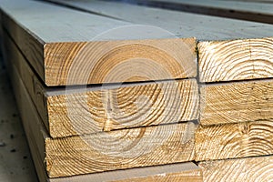 Stack of new wooden studs at the lumber yard. Wood timber construction material. Shallow depth of field effect