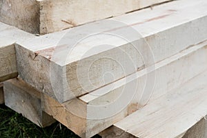 Stack of new wooden studs at the lumber yard. Wood timber construction material. Shallow depth field effect