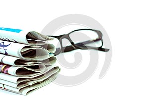 A stack of newspapers with glasses.