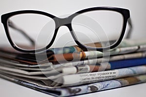 Stack of newspapers and glasses in black and white