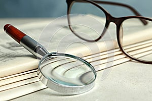Stack of newspapers, magnifier and glasses. Search concept