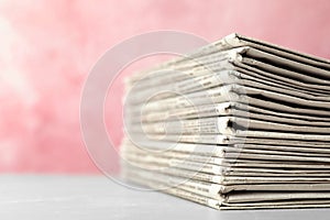 Stack of newspapers on pink background. Journalist`s work