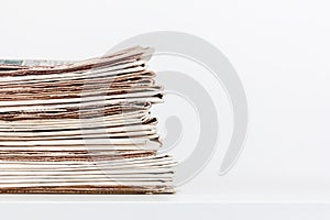 a stack of newspapers on a table on a white background