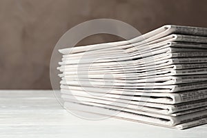 Stack of newspapers on white table. Journalist`s work