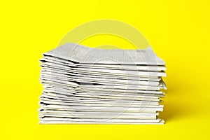 Stack of newspapers on yellow. Journalist`s work