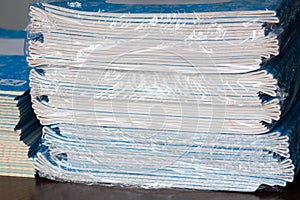 Stack of Notebooks. Back to school. A pack of blue school notebooks on the table in a classroom. Stack of exercise books. Packing