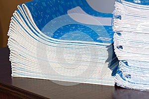 Stack of Notebooks. Back to school. A pack of blue school notebooks on the table in a classroom. Stack of exercise books. Packing