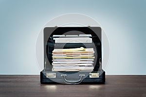 Stack of office paperwork in black leather briefcase