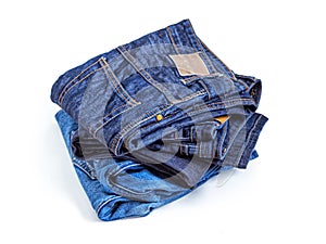 Stack of old blue jeans on a white background