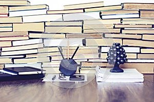 Stack of old book on wooden table, laptop computer, notebook, smartphone, stationery and paperweight. Education writer concept