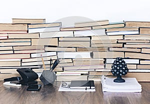 Stack of old book on wooden table, notebook, smartphone, stationery and paperweight. Education writer concept background