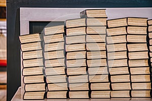 Stack of old books bears cultural and devotional meaning. Pile of volumes in a church conveys instruction and education concept