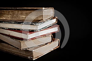 Stack of old books on black background