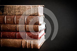 Stack of old books on black background