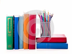 Stack of Old books and color pencils isolated on white