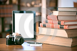 Stack of old books and cup of coffee over wooden table