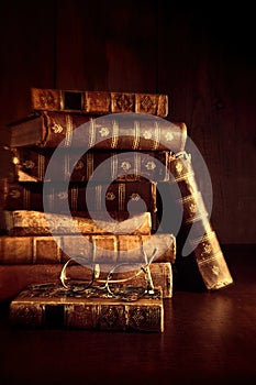 Stack of old books with reading glasses