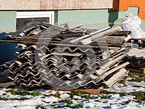Stack of old corrugated asbestos-containing roofing materials - roofing slates
