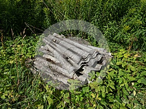 Stack of old corrugated asbestos-containing roofing materials - slates. Material associated with serious and fatal illnesses