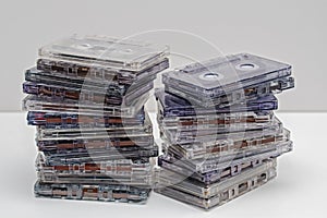 Stack of old dirty audio cassettes on the white shelf.