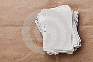 Stack of old envelopes and letters on kraft paper, top view