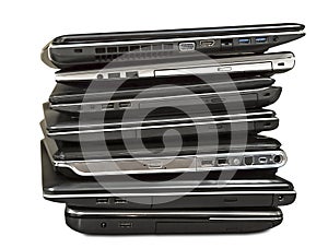 Stack of old laptops awaiting repair isolated on white backgroun