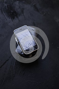 stack of old mobile phones with cracked screens