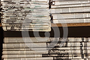 A stack of old newspapers lie on the shelf