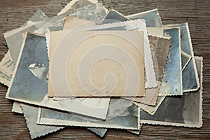 Stack old photos on table. Mock-up blank paper. Postcard rumpled and dirty vintage