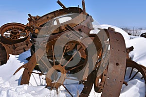 Stack of old rusty steel rims buried in deep snow